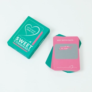 Close-up of Sweet Commands couple game cards with pink scratch-off hearts and turquoise box
