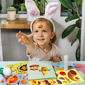 Close-up of a child doing DIY Thanksgiving crafts with cartoon turkey and pumpkin stickers