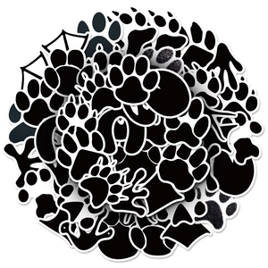 Stack of black and white animal paw print stickers in various doodle shapes and patterns