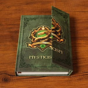 Détail du carnet académie de magie vert vintage avec blason de serpent doré sur bois
