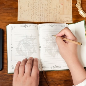 Détail d'un carnet vintage vert avec filigrane de lion couronné et pages intérieures lignées