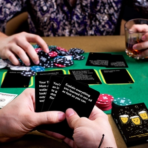 Detailopname van zwarte partyspelkaarten en pokerchips op een groen vilten tafel