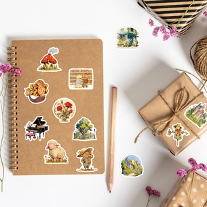 Artistic stickers featuring mushrooms and mermaids on a kraft notebook with gift boxes