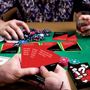 Detail of Truth or Dare party game cards with chips and box in a social setting
