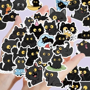 Main tenant divers autocollants mignons de chat noir avec bordure blanche sur fond violet