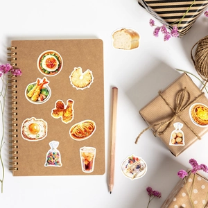 Pegatinas de comida en cuaderno kraft con lápices y flores secas decorativas