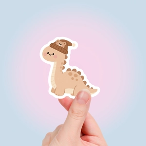 Detail eines niedlichen Dino-Aufklebers mit Bärenmütze für Laptops und Wasserflaschen