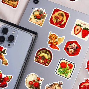 Close-up of vintage flower and angel stickers applied on a laptop and smartphone