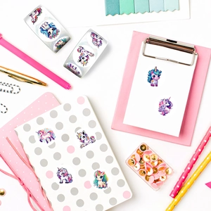 Rollo de lindas pegatinas de unicornio con dibujos animados en un escritorio decorado