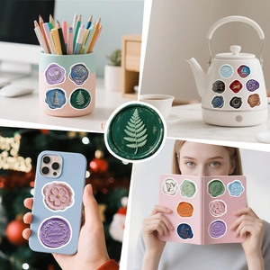 Detail showing vintage wax seal stickers on a notebook, water bottle, and phone case