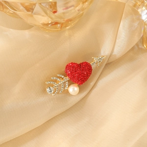 Fashion heart and arrow brooch with red crystals and pearl on champagne silk