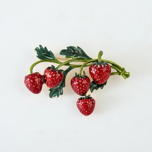 Creative alloy strawberry brooch with red enamel and green leaves on white background