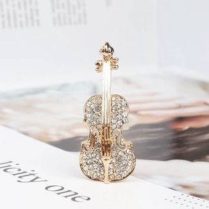 Détail macro d'une broche violon dorée sertie de cristaux blancs étincelants