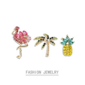 Dettaglio delle spille fenicottero palma e ananas con strass colorati e lucidi
