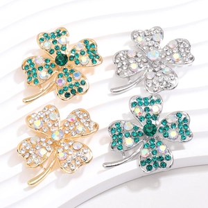 Macro detail of four-leaf clover crystal brooches with sparkling rhinestone inlay details