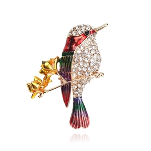 Detailed view of hummingbird brooch with colorful enamel wings and crystal rhinestones