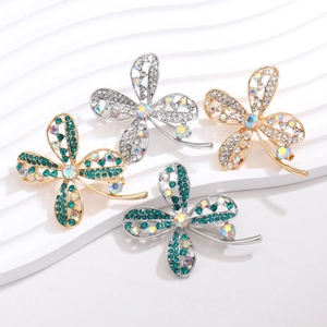 Detail of four-leaf clover brooches with sparkling rhinestones and alloy hollow design
