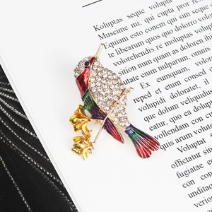 Detailed shot of hummingbird brooch with colorful enamel and sparkling rhinestones