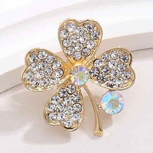 Detailed macro view of gold four-leaf clover brooch featuring iridescent crystals and rhinestones
