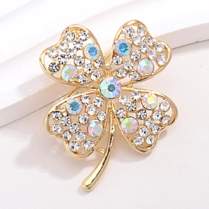 Detail of four-leaf clover brooch featuring gold plating and shimmering AB rhinestones