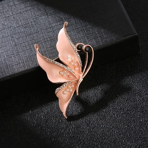 Elegant gold butterfly brooch with pink enamel, white pearls, and sparkling crystals