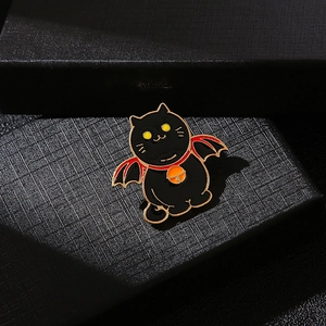 Mignonne broche chat noir en émail avec ailes de chauve-souris sur un coffret à bijoux