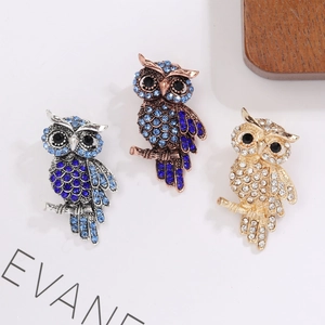 Detailed view showing three variations of elegant owl brooches with colorful rhinestones