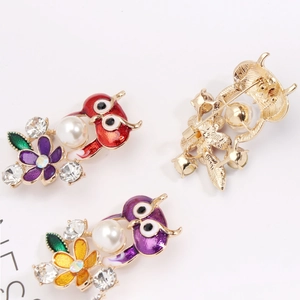 Charmante broche hibou avec perles et cristaux sur une finition en émail doré