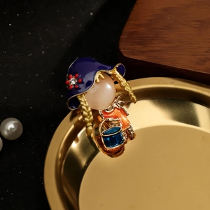 Detail van de broche meisje met blauwe emaille hoed, gouden vlechten en parelaccenten