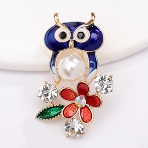 Détail d'une jolie broche hibou avec perle blanche et accents de zircon brillant