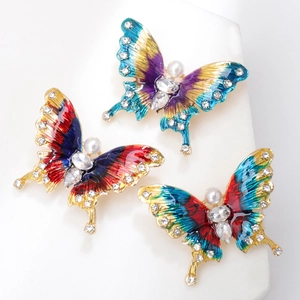 Dettaglio di spille a farfalla colorate con smalto, strass e perle sintetiche