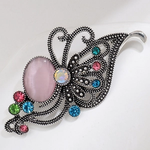 Macro shot of retro butterfly brooch with pink opal stone and colorful rhinestones