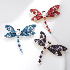 Detailed macro view of dragonfly brooches featuring colorful rhinestones and pearls