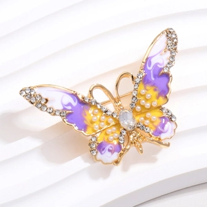 Vue détaillée d'une broche papillon en émail avec dégradés violet jaune et perles
