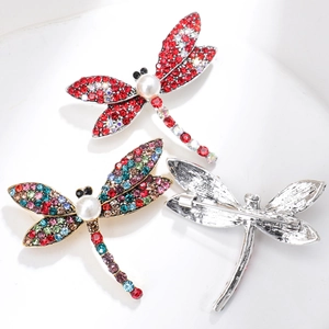 Detailed view of vintage dragonfly brooches with colorful rhinestones and silver pins