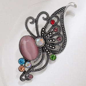 Close-up of vintage butterfly brooch with purple cat eye stone and colorful rhinestones