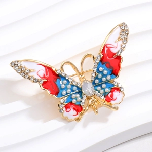 Macro d'une broche papillon avec ailes en émail coloré et strass étincelants