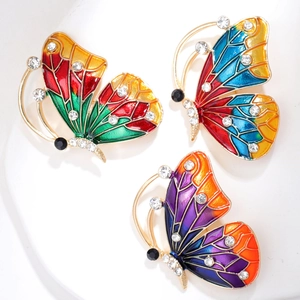 Dettaglio di spille a farfalla vintage con smalto colorato e strass scintillanti su oro