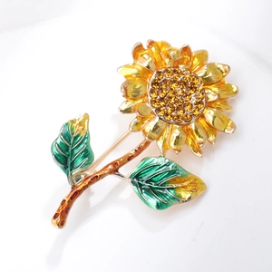 Macro detail of sunflower brooch featuring yellow petals and sparkling rhinestone core
