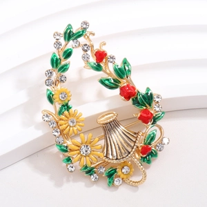 Detail of enamel flower brooch with green leaves, yellow daisy, red berries and rhinestones