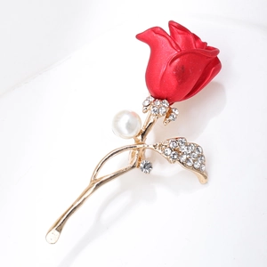 Detailed macro view of an elegant red rose brooch with inlaid zircons and a white pearl