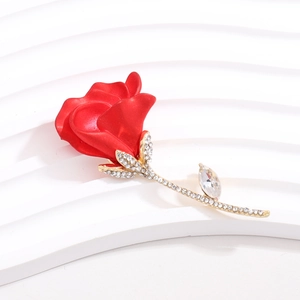 Elegant red rose brooch with gold stem and sparkling crystals on a minimalist background