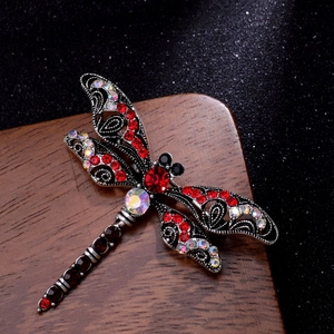 Macro detail of vintage dragonfly brooch with red rhinestones and antique silver metal