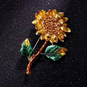 Detail of sunflower brooch with yellow enamel petals and sparkling orange rhinestone center