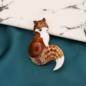 Détail d'une broche renard en émail rouge et strass ambrés étincelants