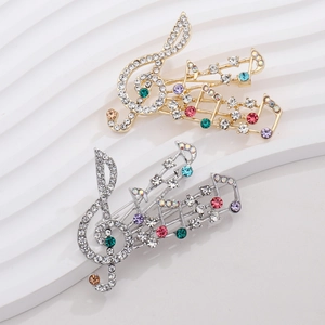 Elegant musical note and violin brooch with colorful crystals on a white pedestal