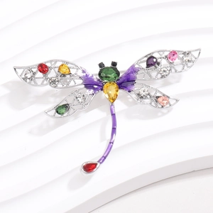 Detail van libelbroche met kleurrijke strass-steentjes en holle vleugels op witte basis