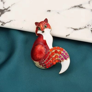 Vue détaillée d'une broche renard avec strass colorés et émail sur marbre et soie