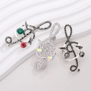 Macro detail of treble clef music note brooches with inlaid crystals and colorful rhinestones