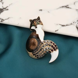 Vue détaillée d'une broche renard avec strass colorés et émail sur fond textile
